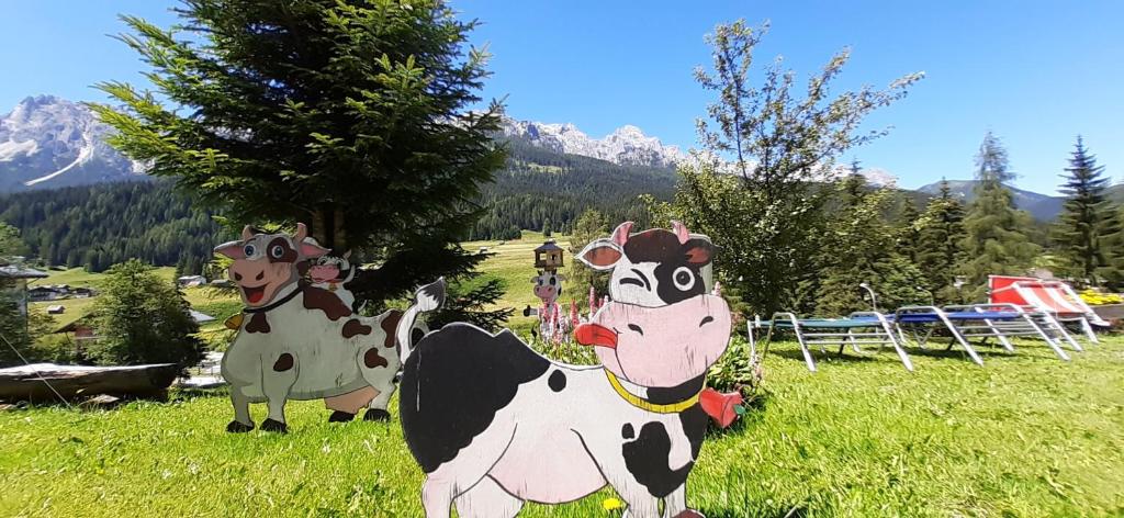 two cow statues in a field of grass at La Pineta Apartment in Padola