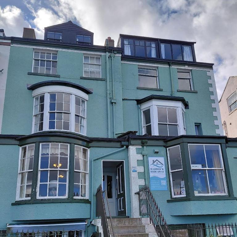 a blue apartment building with a blue house at Haddock Hideaway at The Whiteley in Scarborough