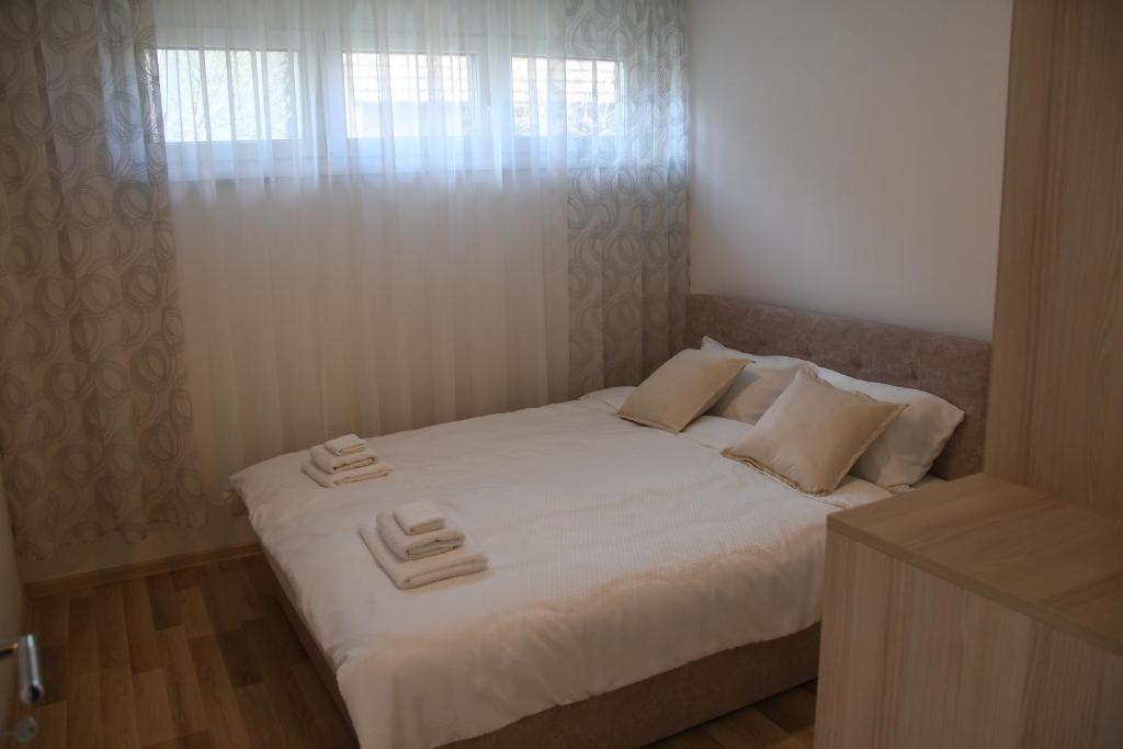 a bedroom with a white bed with towels on it at Prestige in Šabac