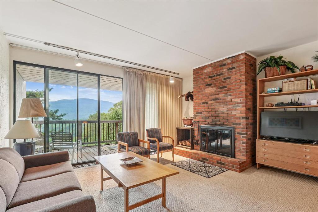 a living room with a couch and a fireplace at Notchbrook 17ABC in Stowe