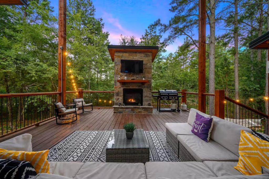 a living room with a couch and a fireplace on a deck at Moonlight Trail in Broken Bow