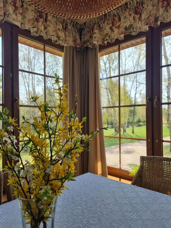 a dining room with a table with a vase of flowers at Zacisze Jurajskie in Olsztyn