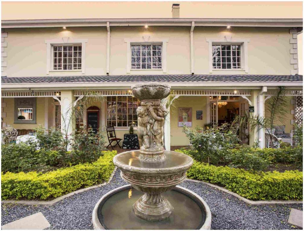 a large fountain in front of a house at De Ark Guest House in Lydenburg