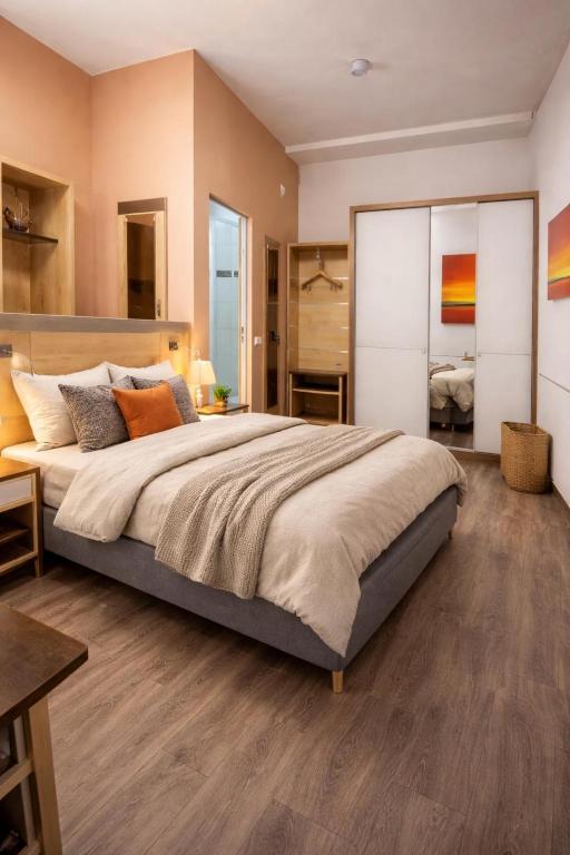 a large bedroom with a large bed and wooden floors at Hotel Moji 5 Solingen in Solingen