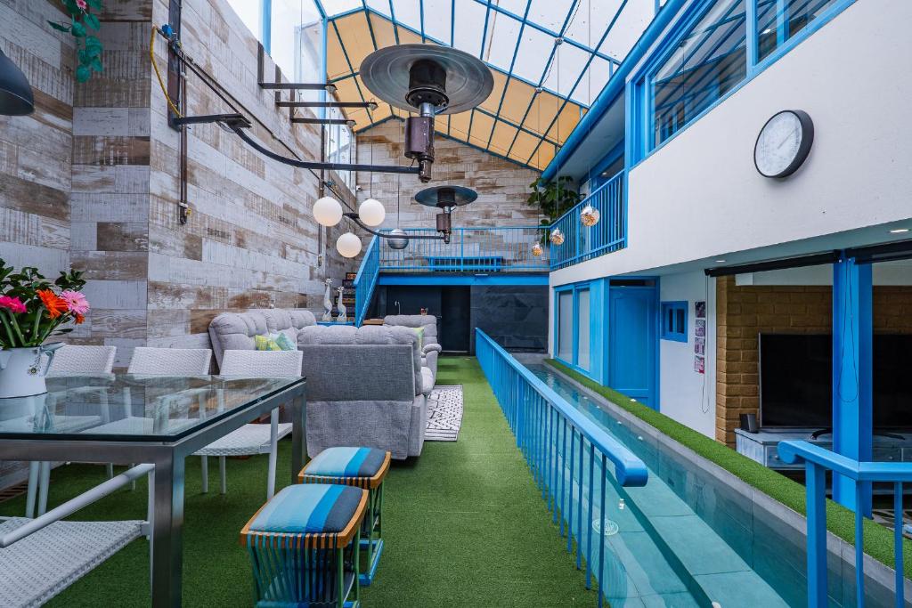 a dining room with a glass table and blue chairs at Casa azul in Villa de Leyva