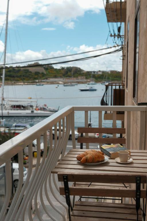 a table with a plate of food on a balcony at Tan-Nanna by Shmoo, Sliema Ferries in Sliema