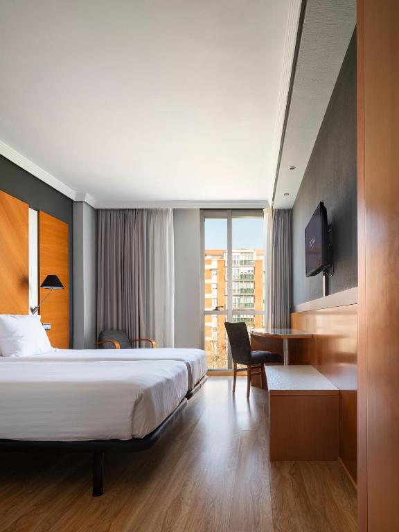 a hotel room with a bed and a desk at Dorma Juan de Austria in Valladolid