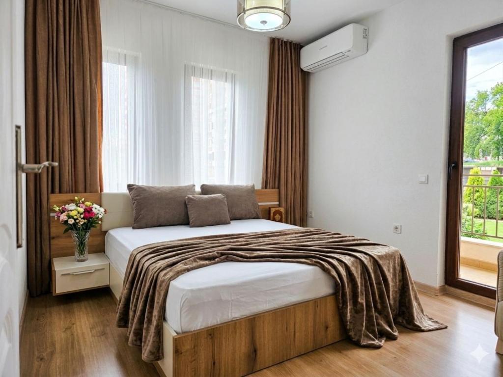 a bedroom with a bed and a large window at Kasibel Suites in Sandanski