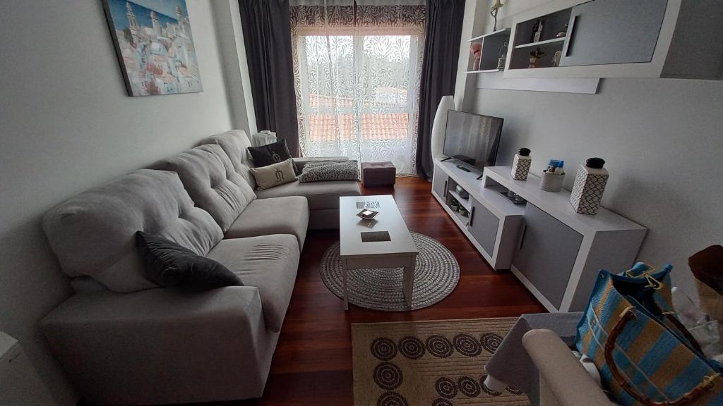 a living room with a couch and a tv at Gavor 68 in A Pobra do Caramiñal