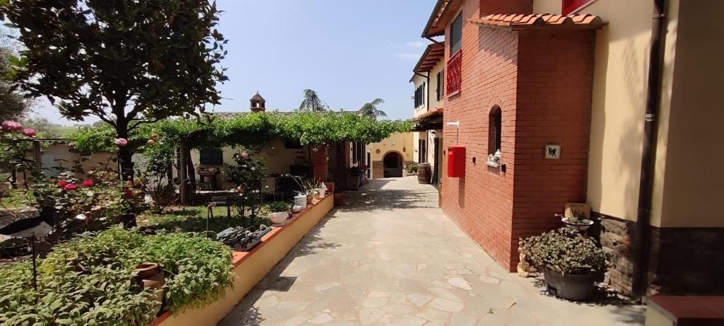 an alley with plants and a brick building at B&B Casa Fattorini in Cortona