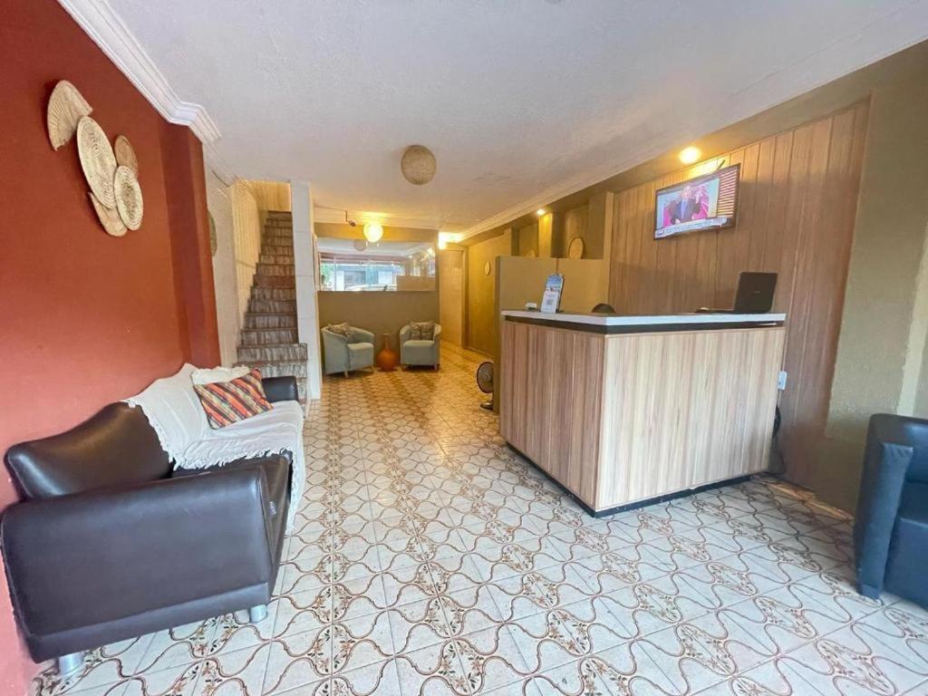 a hotel lobby with a reception desk and a chair at Pousada Casamar in Maceió