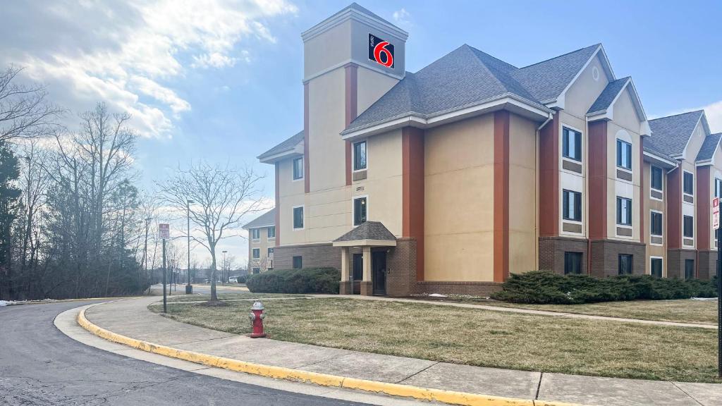 a large building with a clock tower on a street at Studio 6 Chantilly VA Washington Dulles Airport in Chantilly