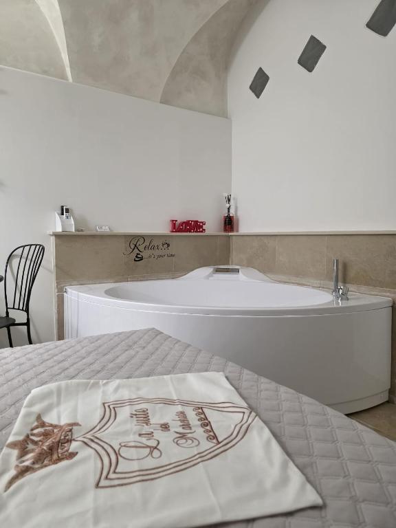 a bathroom with a tub and a bed with a towel at La suite del Marchese a Vieste in Vieste