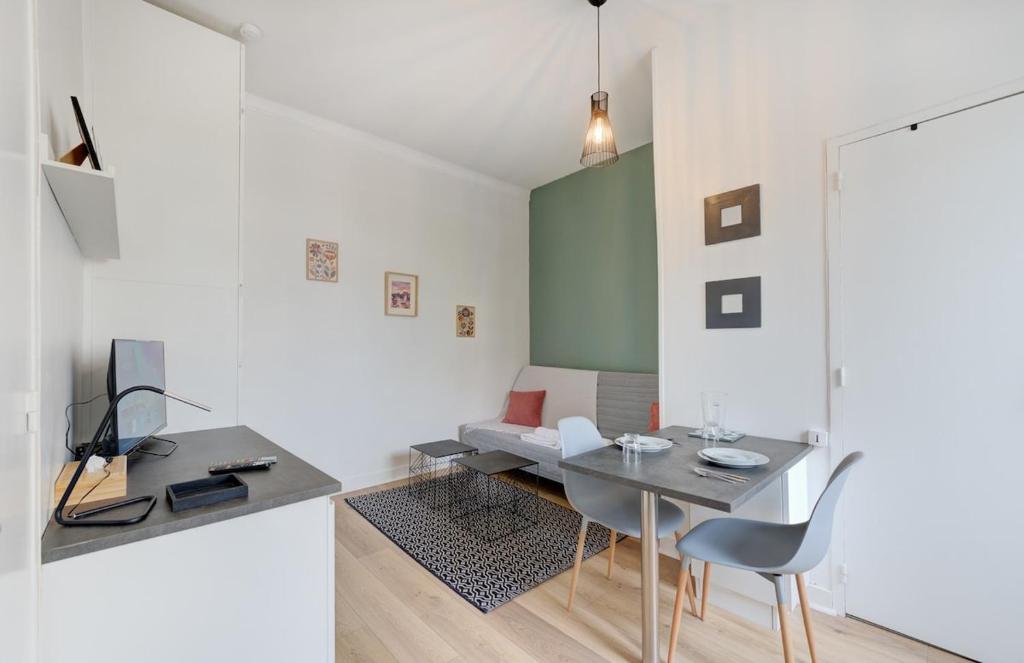a room with a table and chairs and a couch at Le Parvis - Studio cosy hyper centre - Proche gare in Tours