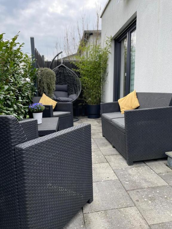 a row of wicker chairs and tables on a patio at Schöfferles Ferienwohnung mit Sauna in Keidelheim
