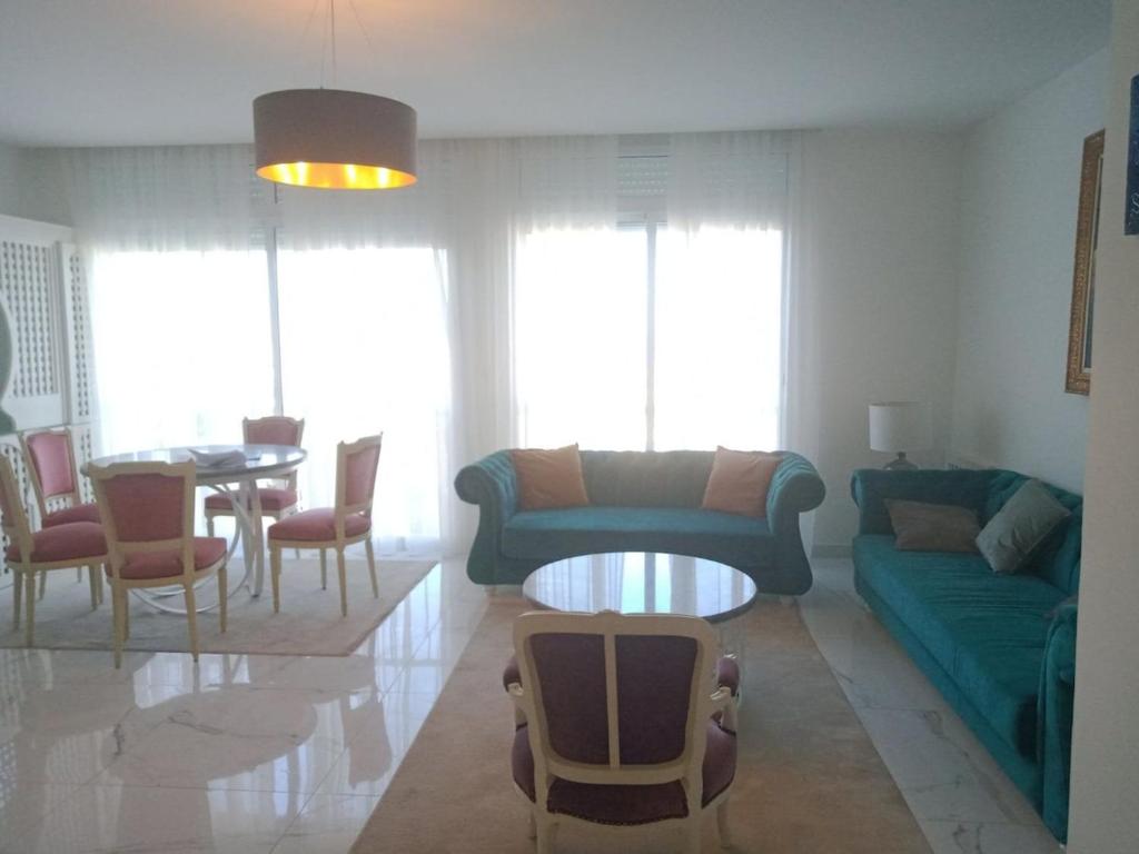 a living room with a couch and a table at L'appartement en face de la baie in Sidi MʼHamed