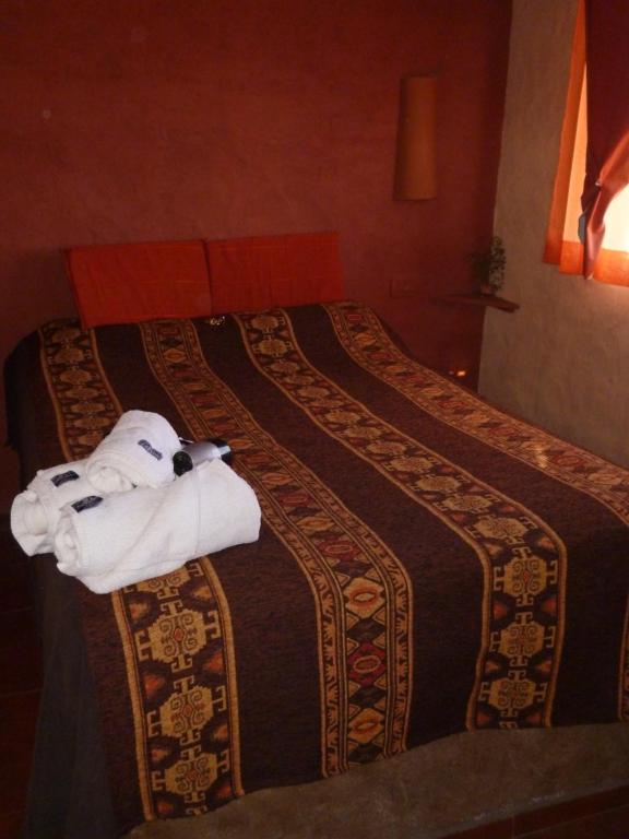une chambre d'hôtel avec deux lits avec des serviettes dessus dans l'établissement Mamuna Posada un lugar para disfrutar de a dos, à Uspallata