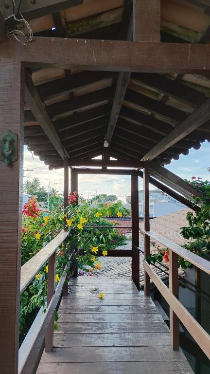 a wooden walkway with flowers on the side of a building at Pousada Laia in Conde