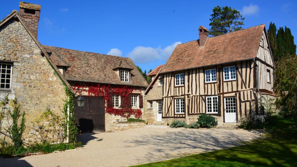 an old house with a garage and a stone building at Le Clos des Grands Jardins in Giverny