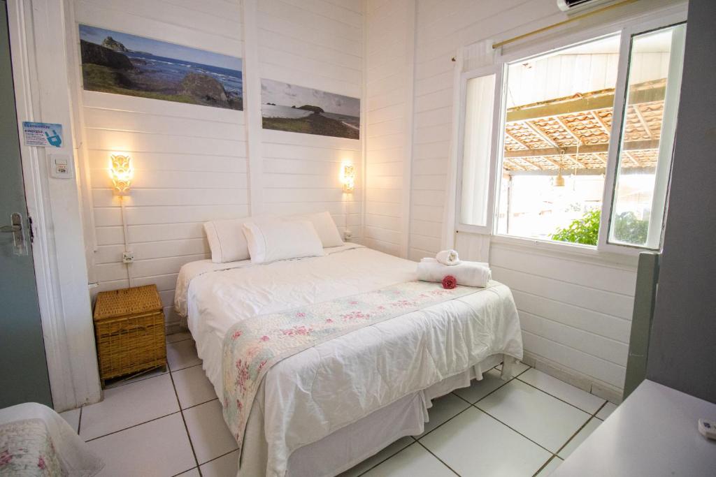 a small bedroom with a bed and a window at Pousada da Carmô in Fernando de Noronha