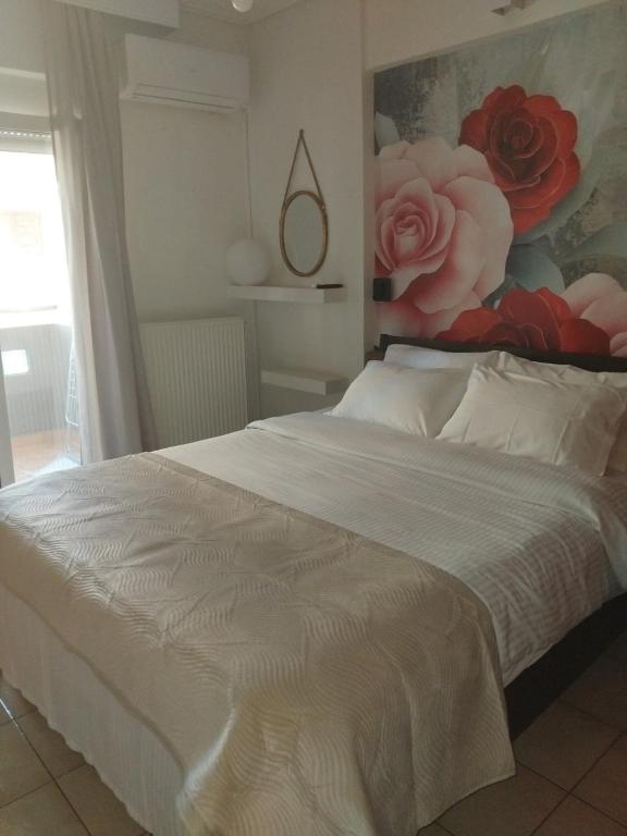 a bedroom with a white bed with a painting on the wall at The Spot 1 in Larisa