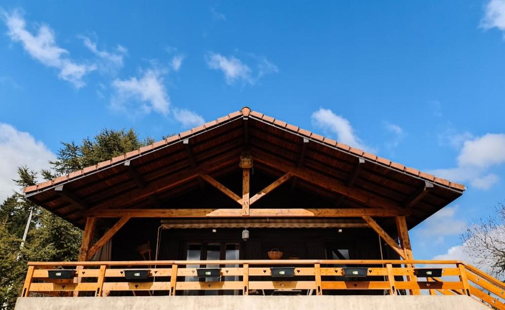 a wooden pavilion with a blue sky in the background at Le chalet de Maryvonne in Gibles