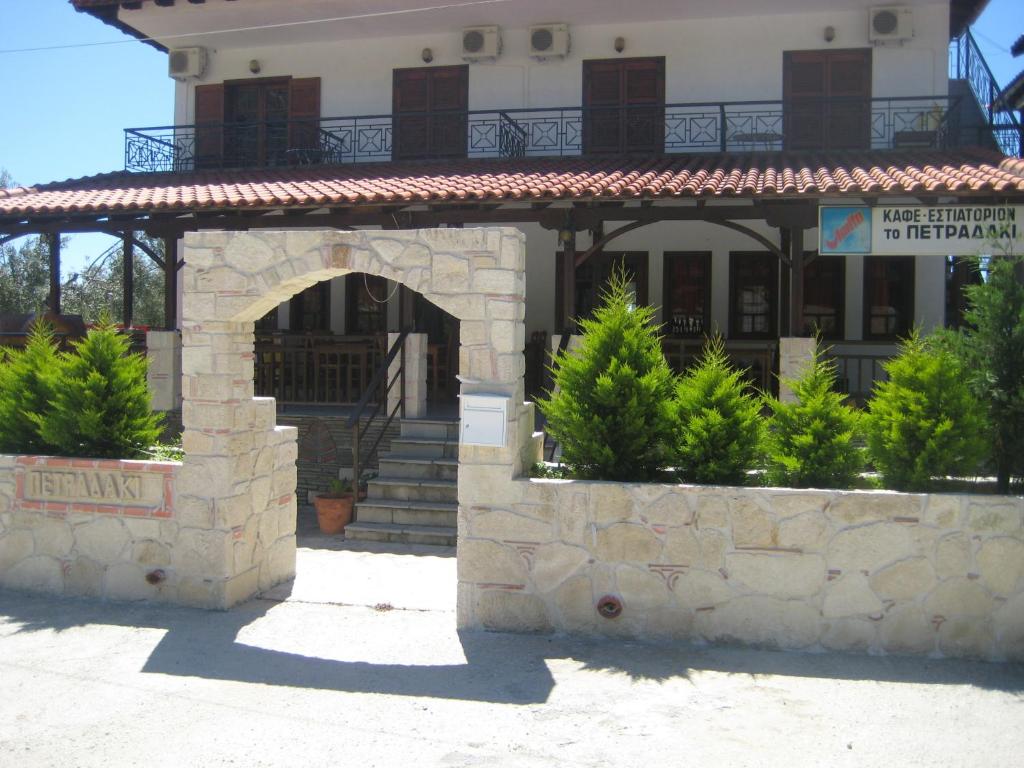 ein Gebäude mit einem Torbogen vor einem Gebäude in der Unterkunft Petradaki Apartments in Mola Kaliva