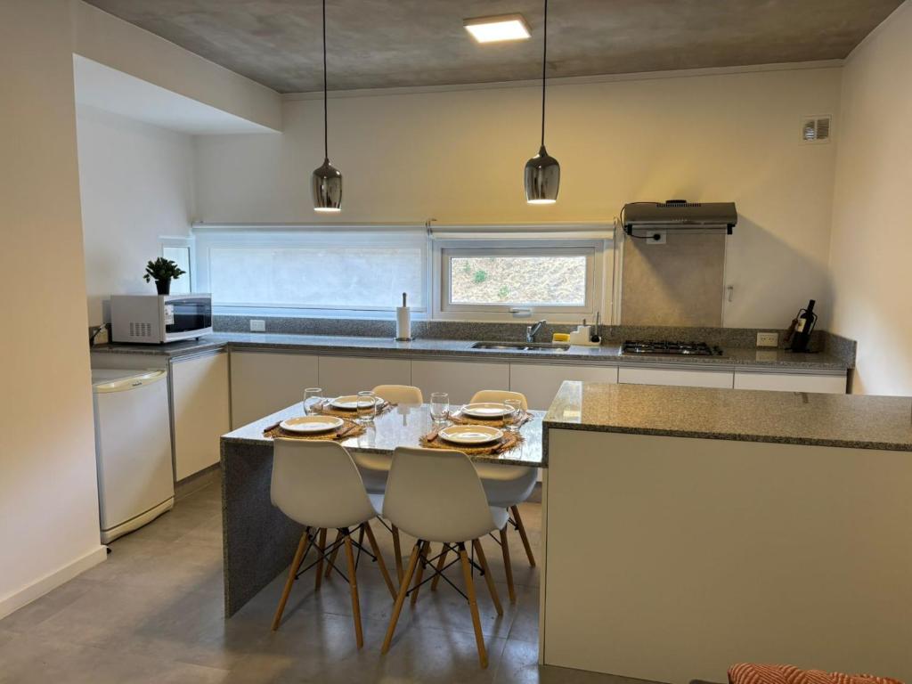 a kitchen with a table and chairs in it at Altamar a metros del Hospital Regional y Cabin in Comodoro Rivadavia