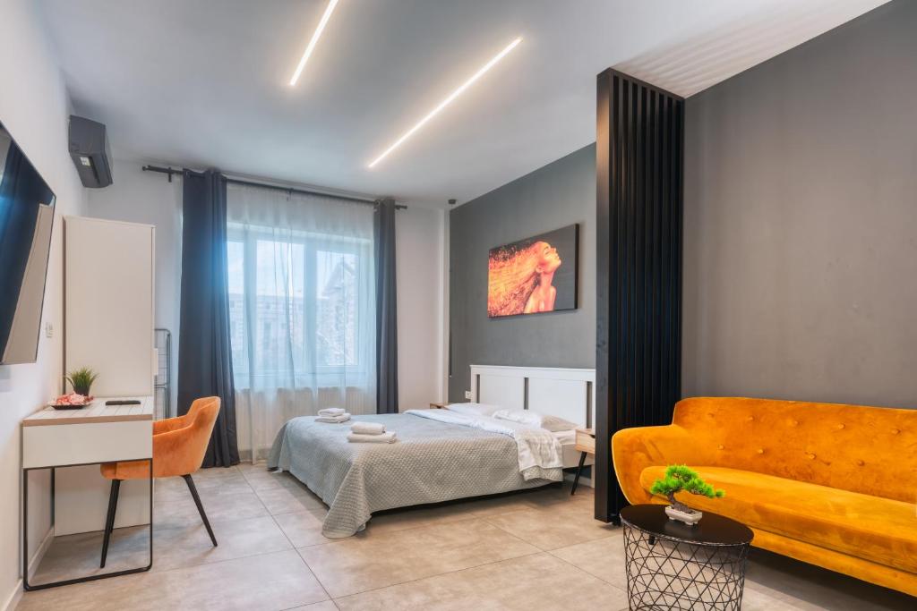 a bedroom with a bed and a couch at Old Town Apartments Brătianu - City Center Stay in Bucharest