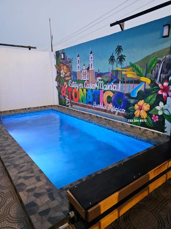 a swimming pool with a mural on the wall at Casa María in Tonatico