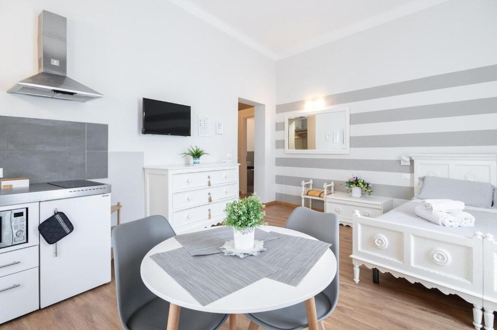a kitchen and living room with a table and chairs at Camera Tua - Falloppio 44 Rooms in Padova
