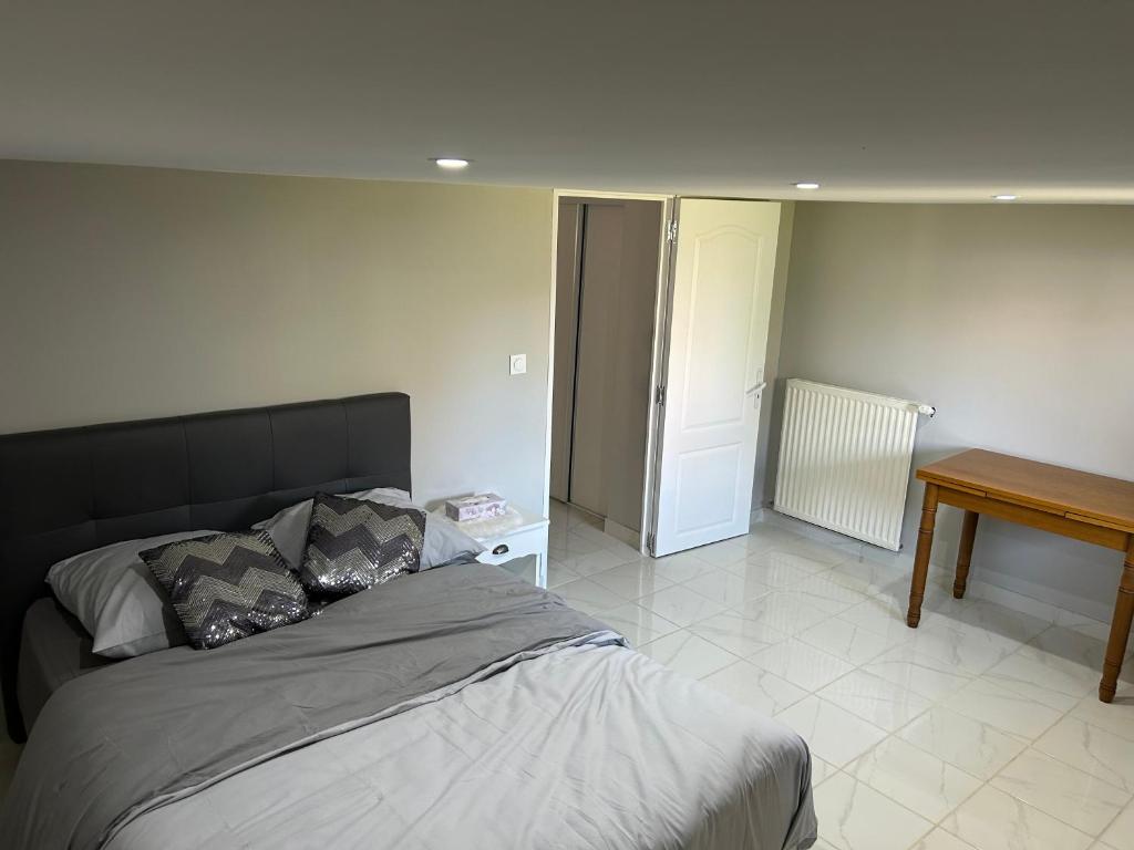 a bedroom with a bed and a table in it at Chez Lina in Chartres
