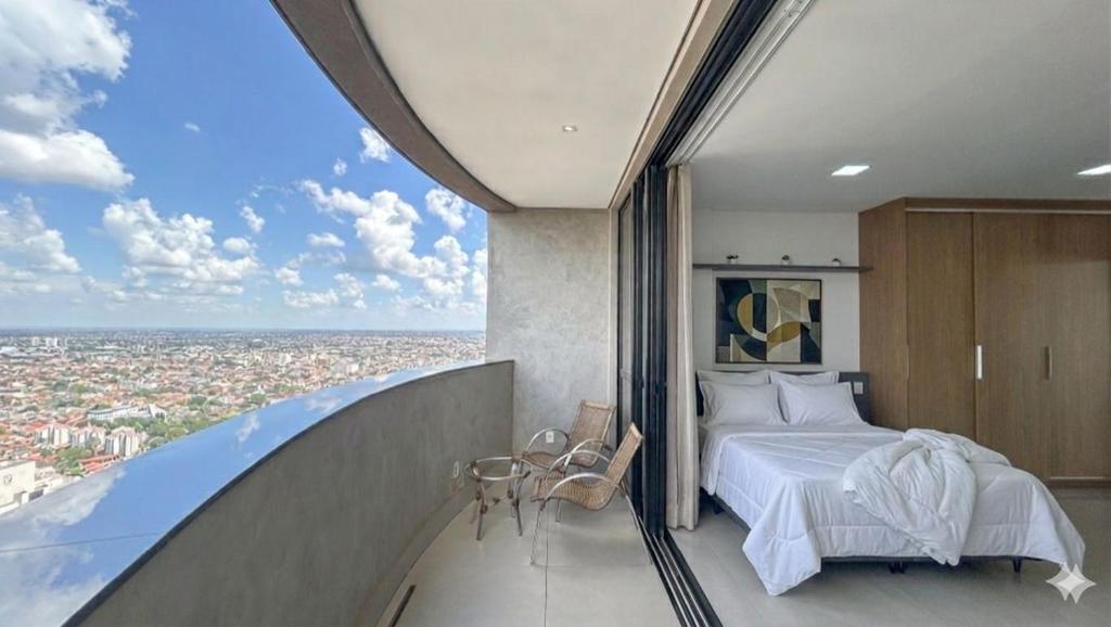 a bedroom with a bed and a view of a city at Studio Aconchegante com Vista do 33º Andar in Campo Grande