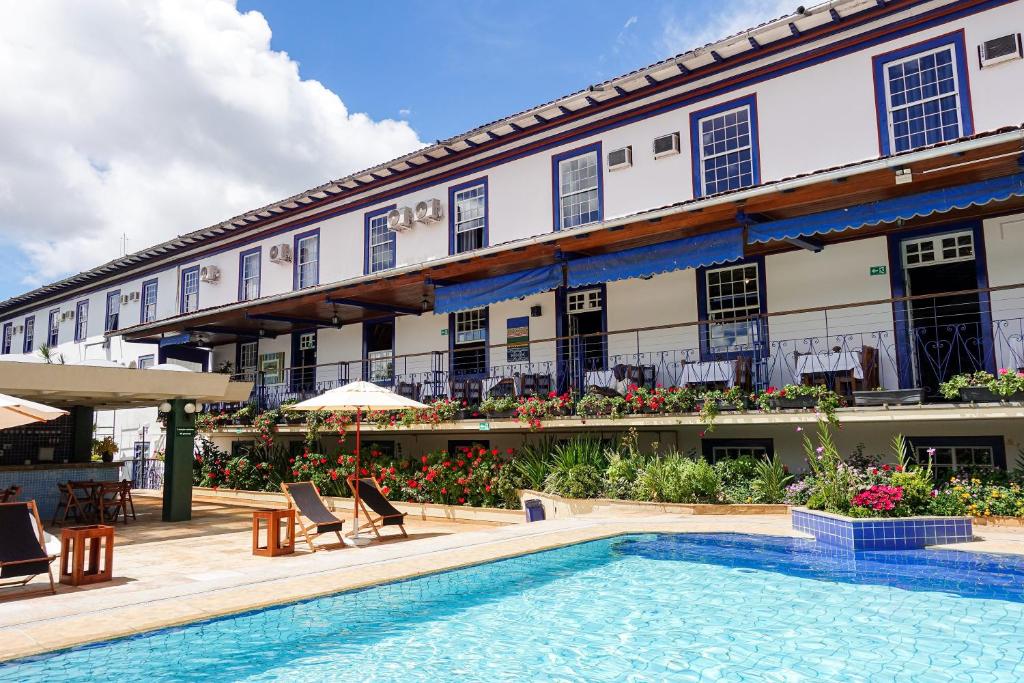 a hotel with a swimming pool in front of a building at Pousada do Garimpo in Diamantina