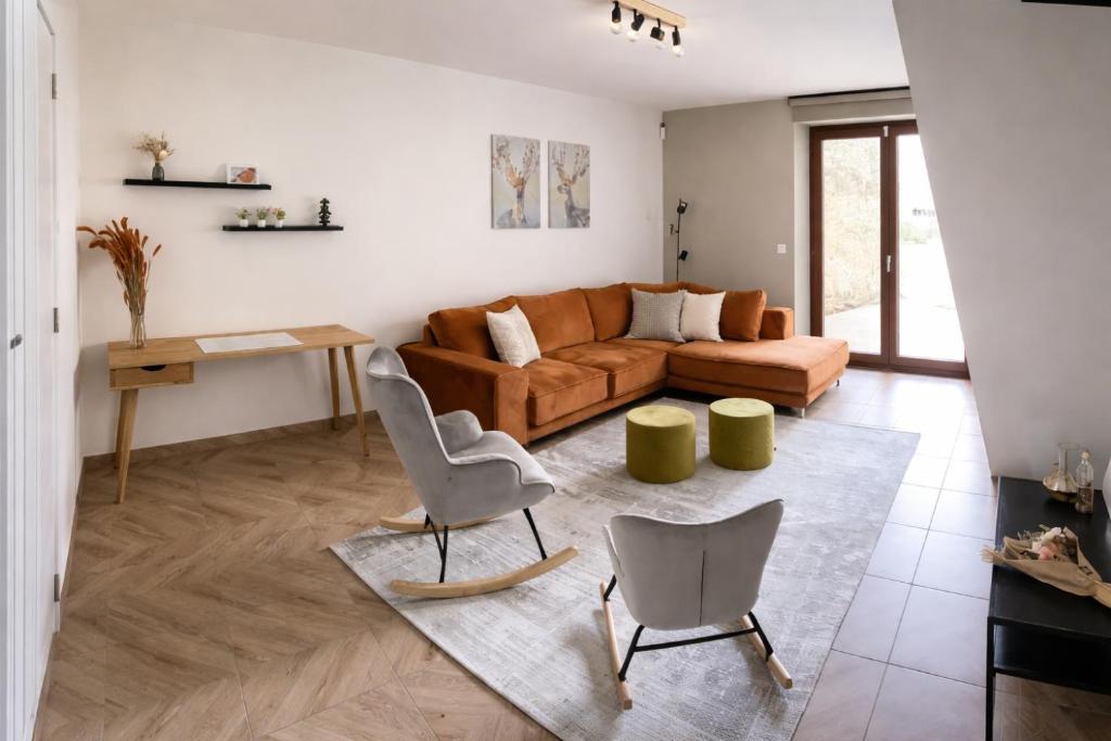 a living room with a couch and two chairs at La Vie En Rose in Muno