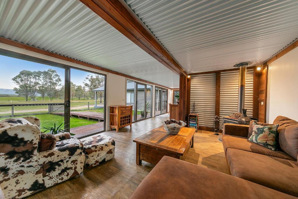 a living room filled with furniture and a large window at Wallaby Lodges in Pokolbin