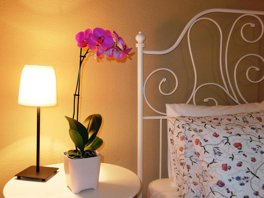 Un dormitorio con una cama con una lámpara y una flor en una mesa en Casa Cotiellu, en Llanes