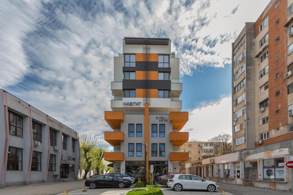 a tall building on a city street with cars parked at Habitat Suites II in Craiova