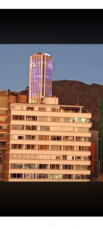 a tall building with blue windows in a city at Hotel Cristals Centro Bogota Estacion las Nieves Calle 18 numero 10 65 in Estación El Salto