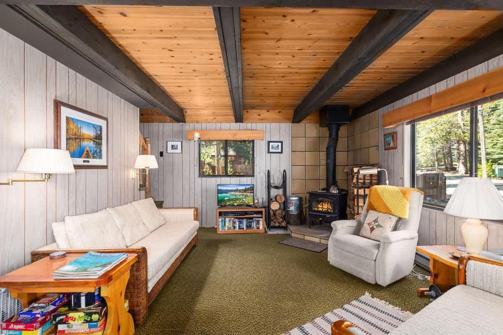 a living room with a couch and a chair and a stove at Mirthwood Den in Tahoma