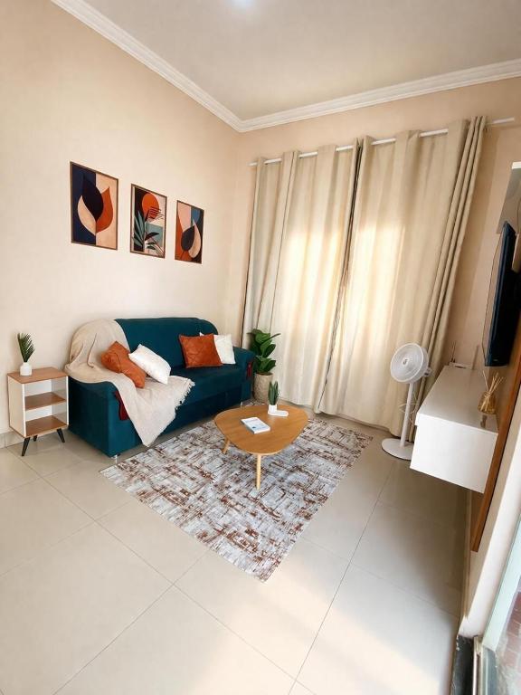 a living room with a blue couch and a table at Casa completa, aconchegante com ar condicionado in Montes Claros