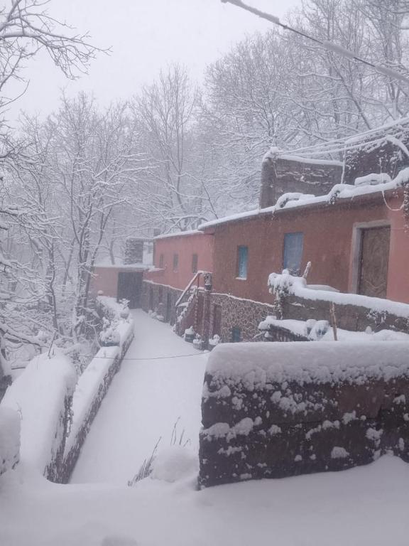 a yard covered in snow next to a house at Gite ousalem timichi in Timichchi