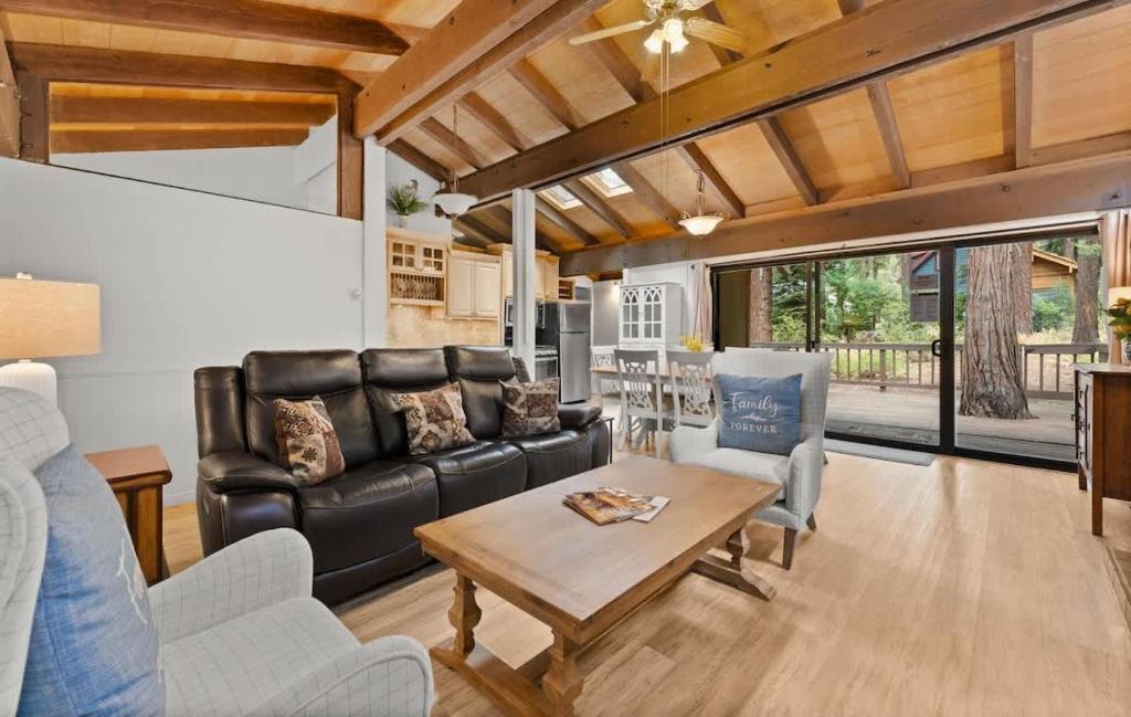 a living room with a leather couch and a table at Dolly Varden Cottage in Kings Beach