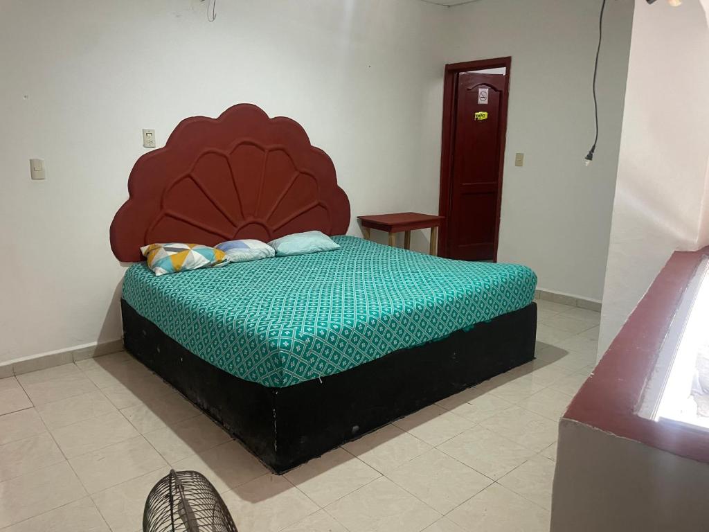 a bed with a large headboard in a room at Hotel Quinta Don Juan in Tapachula