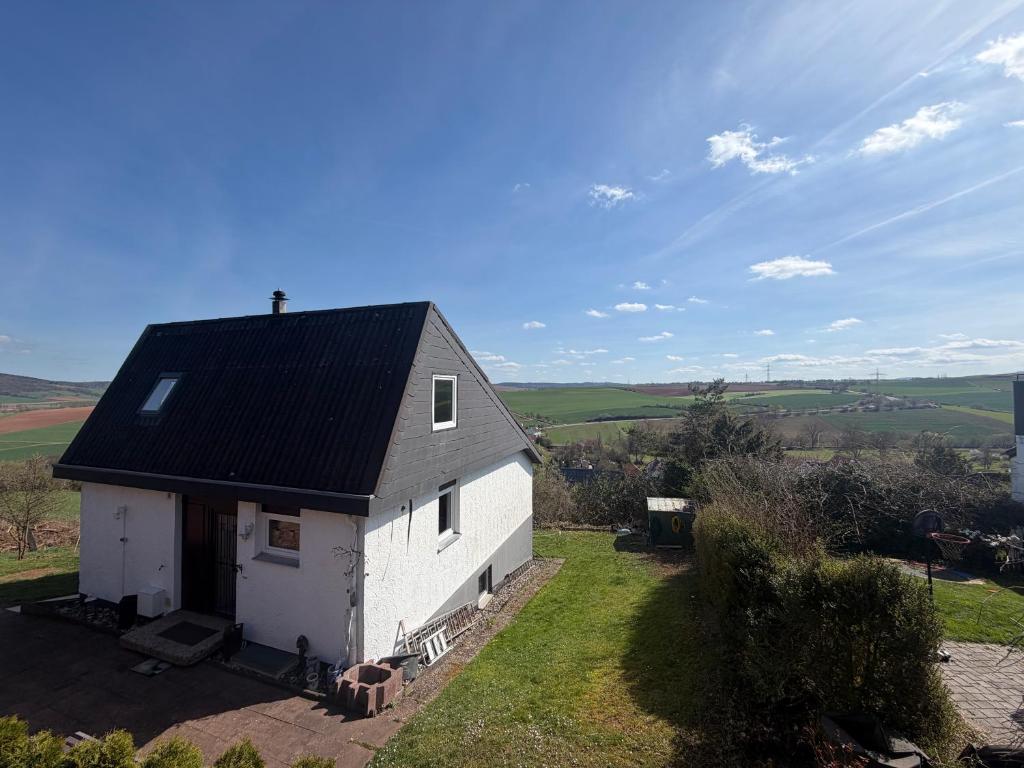 a small white house with a black roof at Sonnenblick in Edertal