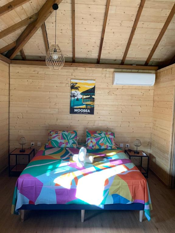 a bedroom with a colorful bed in a room at Fare Teimana Vaianae in Vaianae
