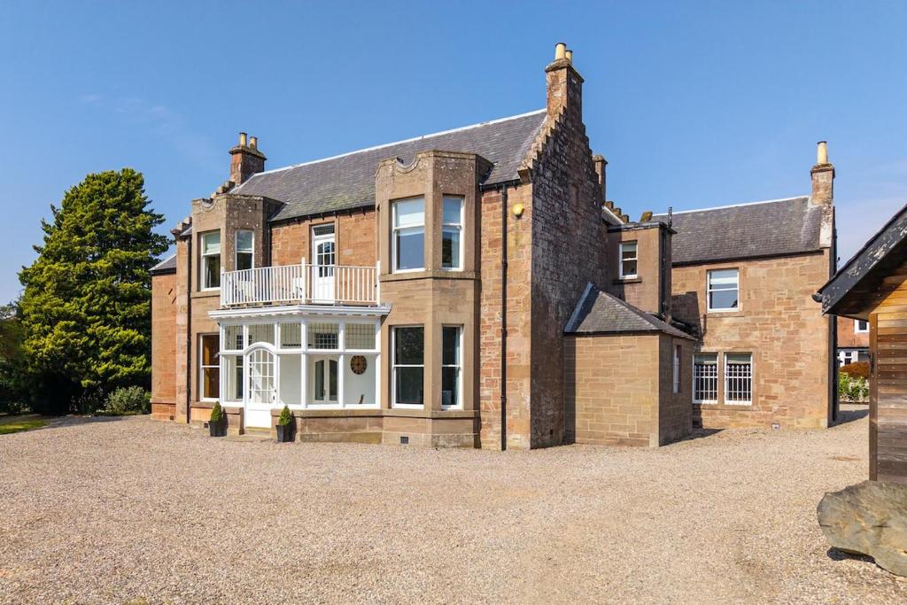 a large brick house with a large driveway at Drumnacree House, Alyth in Alyth