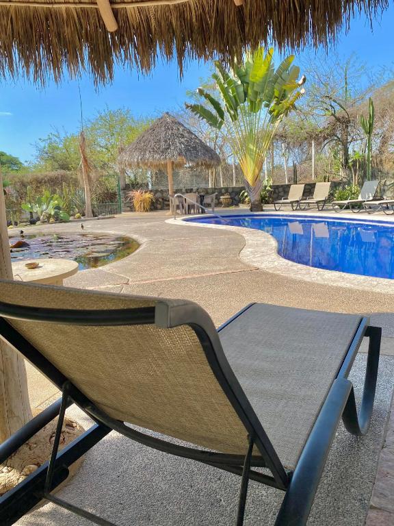 a hammock by a swimming pool at a resort at Casa Del Sol in Lo de Marcos