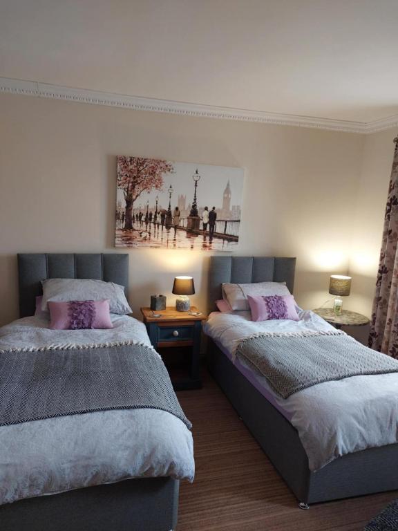a bedroom with two beds and a picture on the wall at Bellevue Inn in Saint Margarets Hope