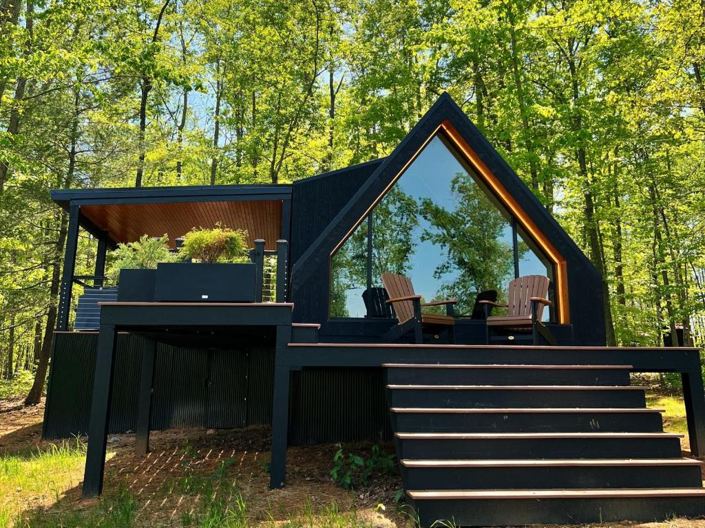 a black house with a deck and a table at Bison Farm - Cabin Brisa in Culpeper
